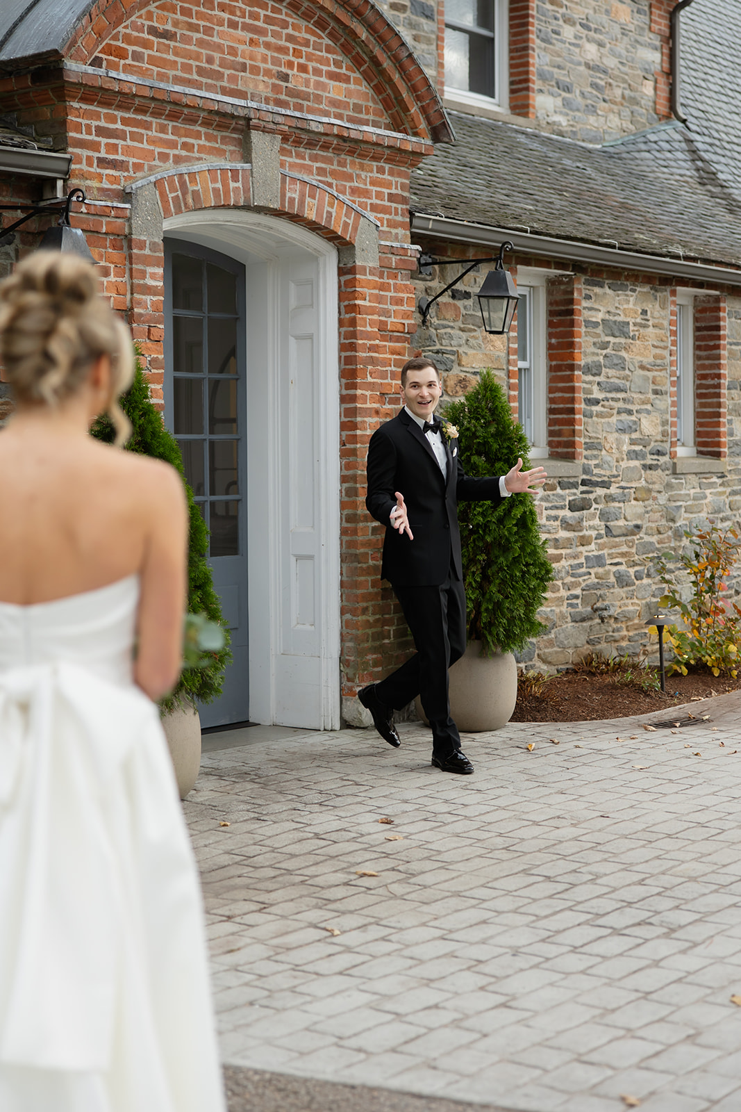 Groom stepping outside stone manor for first look at one of the most beautiful wedding venues in Rhode Island.