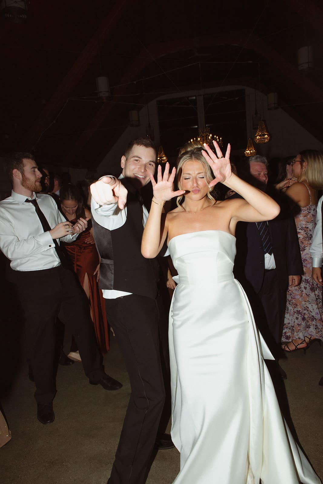 Bride and groom dancing and pointing at the camera during lively reception at one of the most fun wedding venues in Rhode Island.