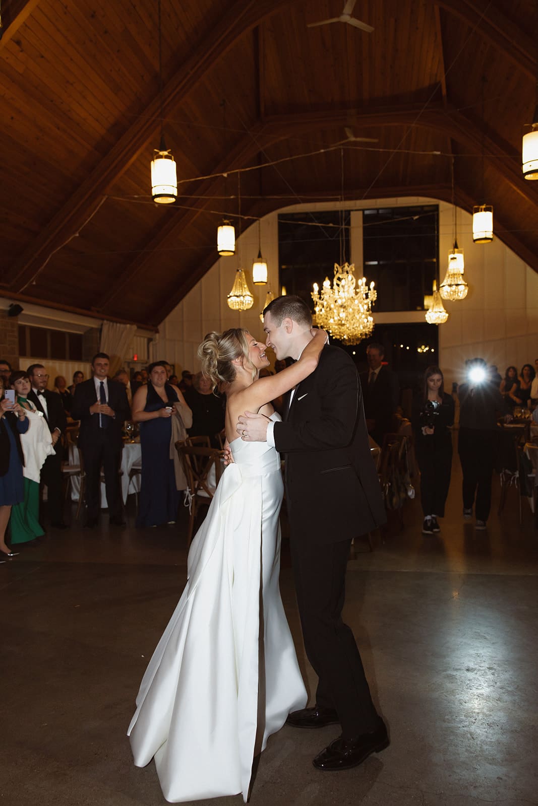 Bride and groom sharing their first dance beneath crystal chandeliers at one of the most elegant wedding venues in Rhode Island.
