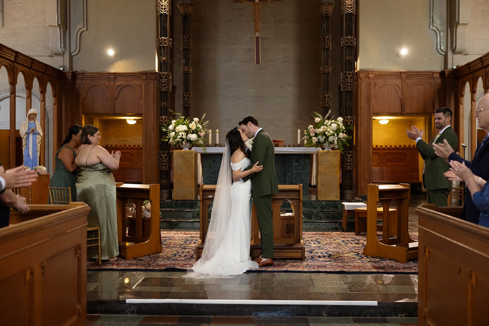 The couple shares their first kiss at the altar as guests look on during a colorful wedding ceremony.
