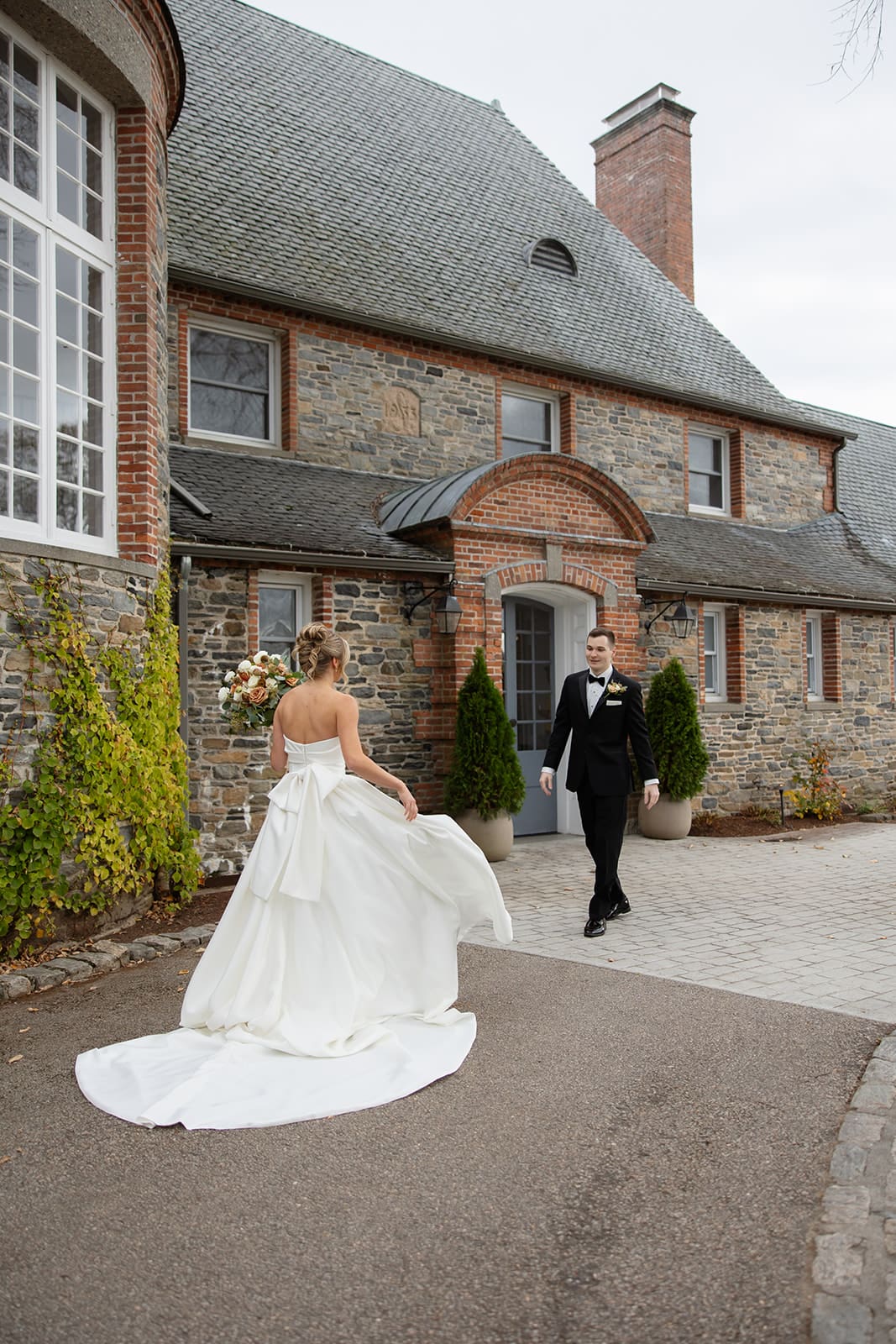 Bride walking toward the groom for their first look outside a historic estate, a beautiful example of Wedding Venues in Rhode Island.
