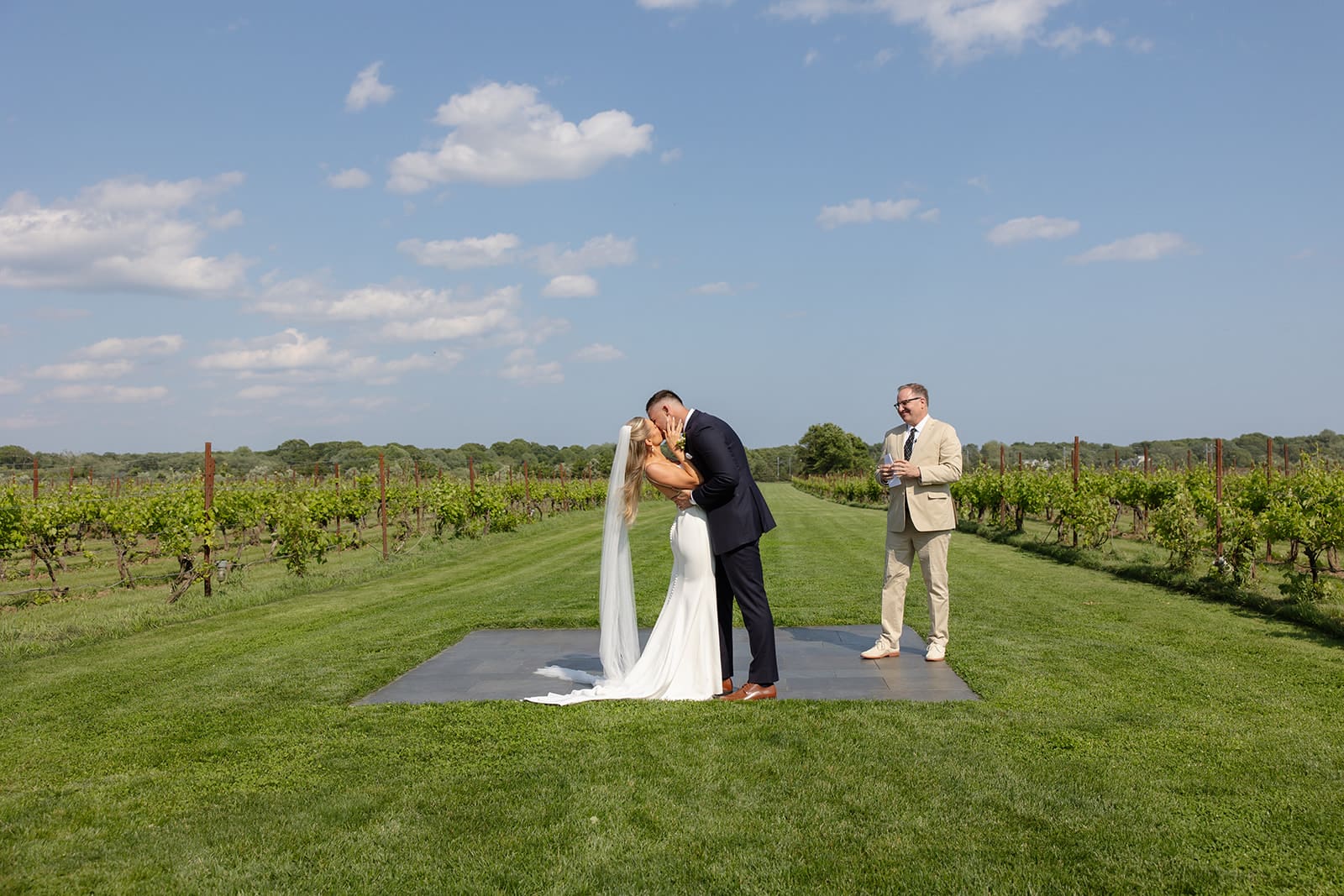 Bride and groom sharing their first kiss during outdoor ceremony at a Connecticut wedding venue