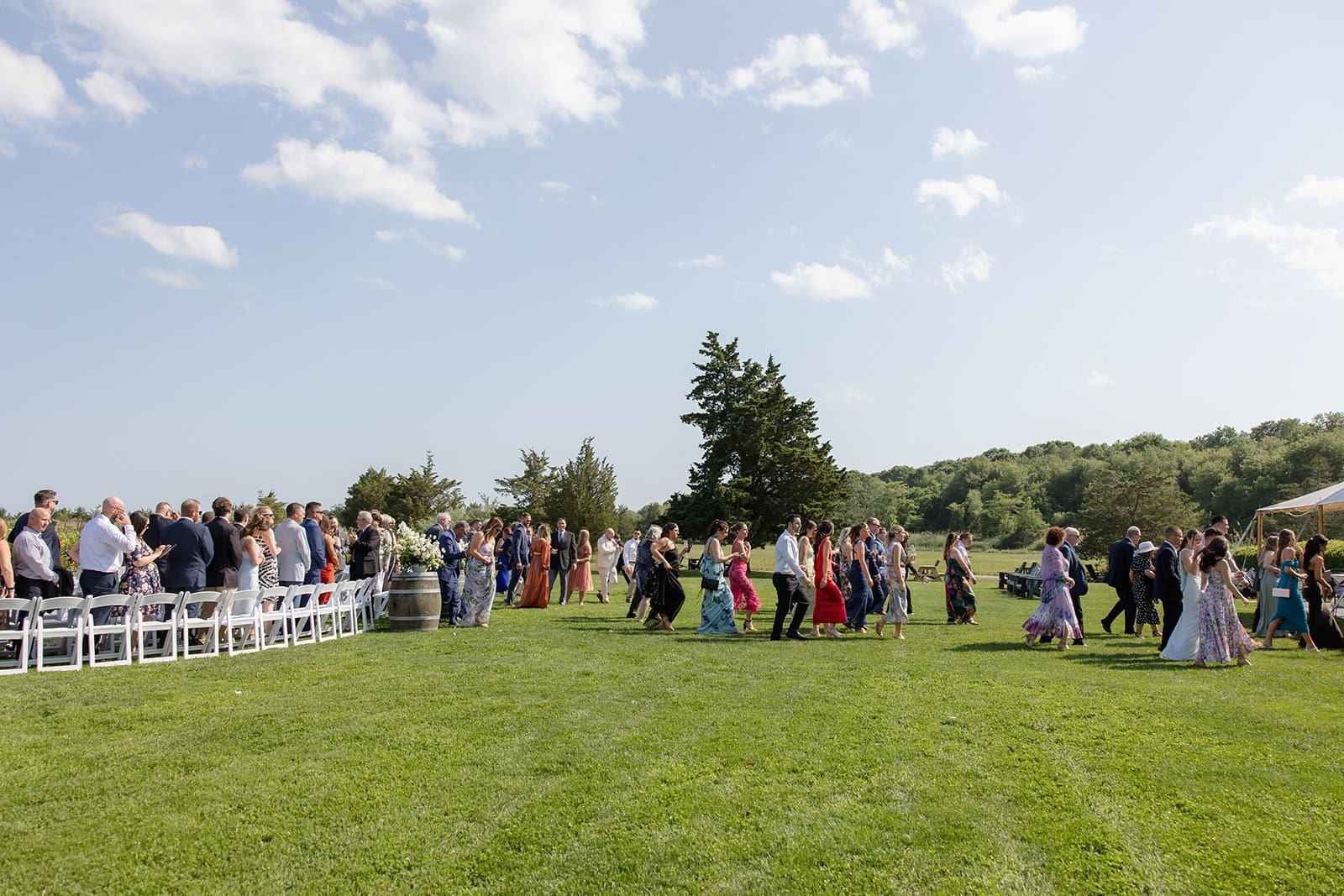 Guests walking across lawn toward outdoor ceremony at a Connecticut wedding venue
