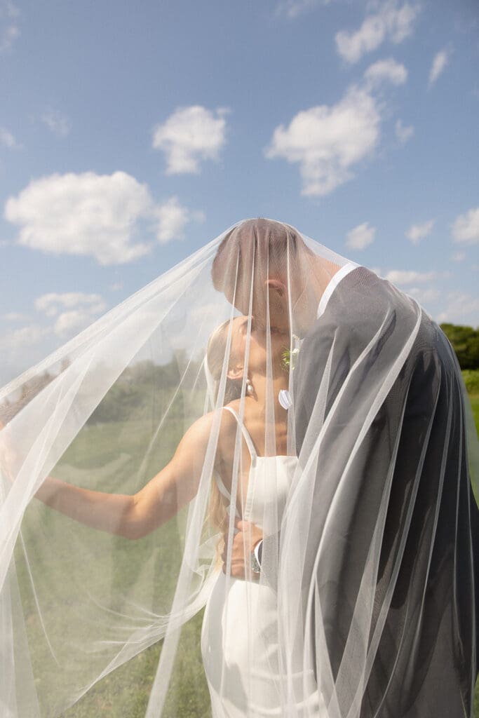 Romantic veil portrait of bride and groom during outdoor portraits at a Connecticut wedding venue
