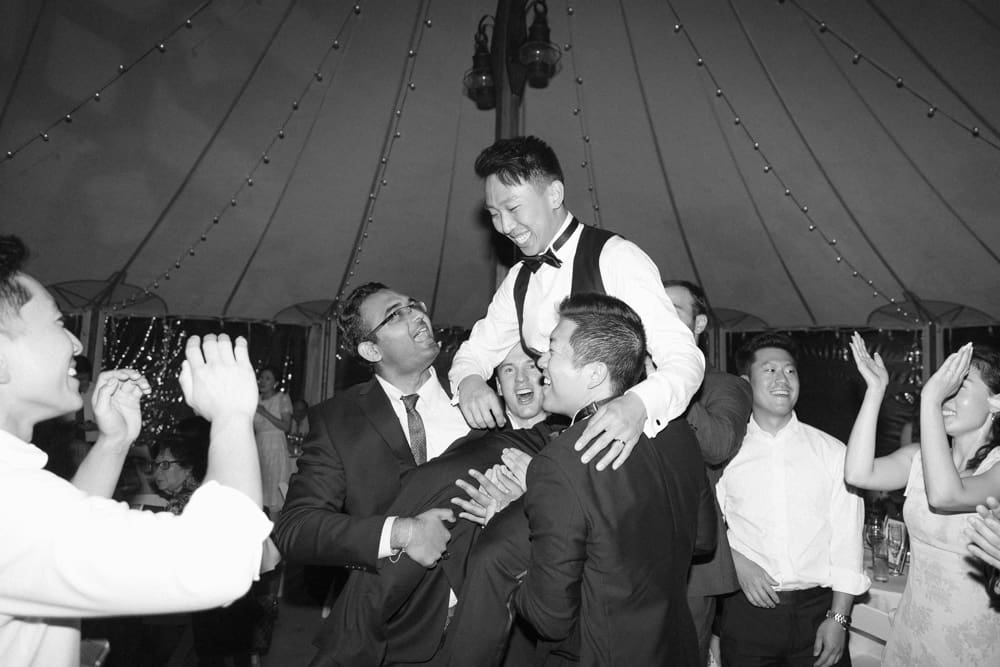Groom lifted into the air by friends on the dance floor during a lively reception at a Massachusetts wedding venue
