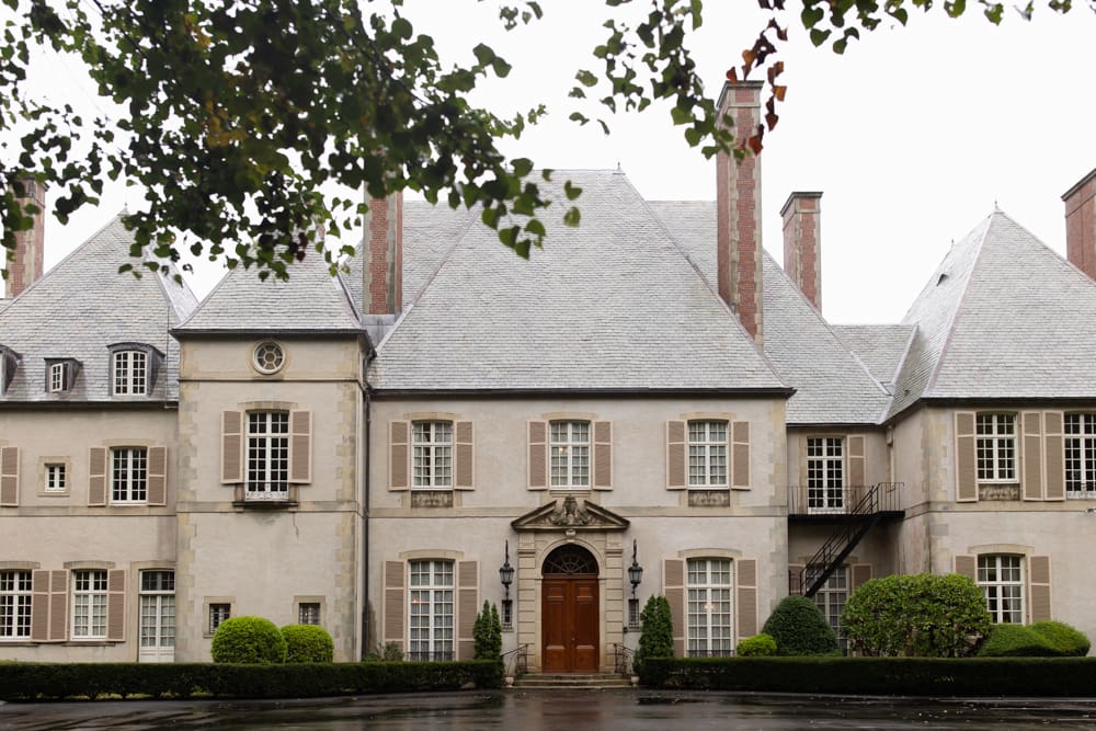 Full exterior of a historic estate with soft shutters and symmetrical architecture at a wedding venue in Rhode island.
