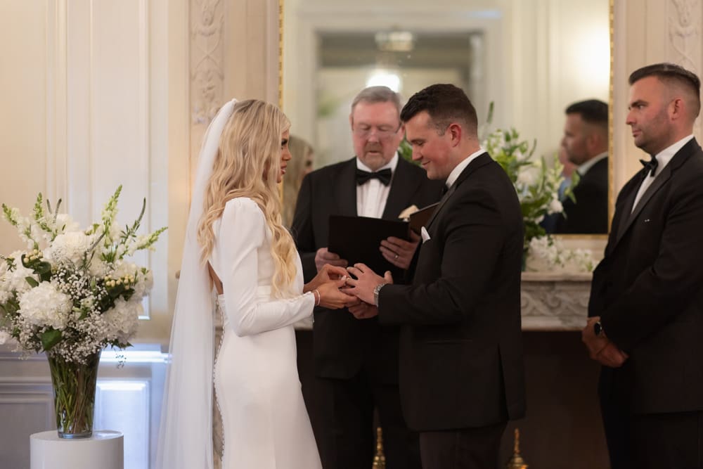 Bride and groom exchanging rings during an intimate indoor ceremony at a wedding venue in Rhode Island.